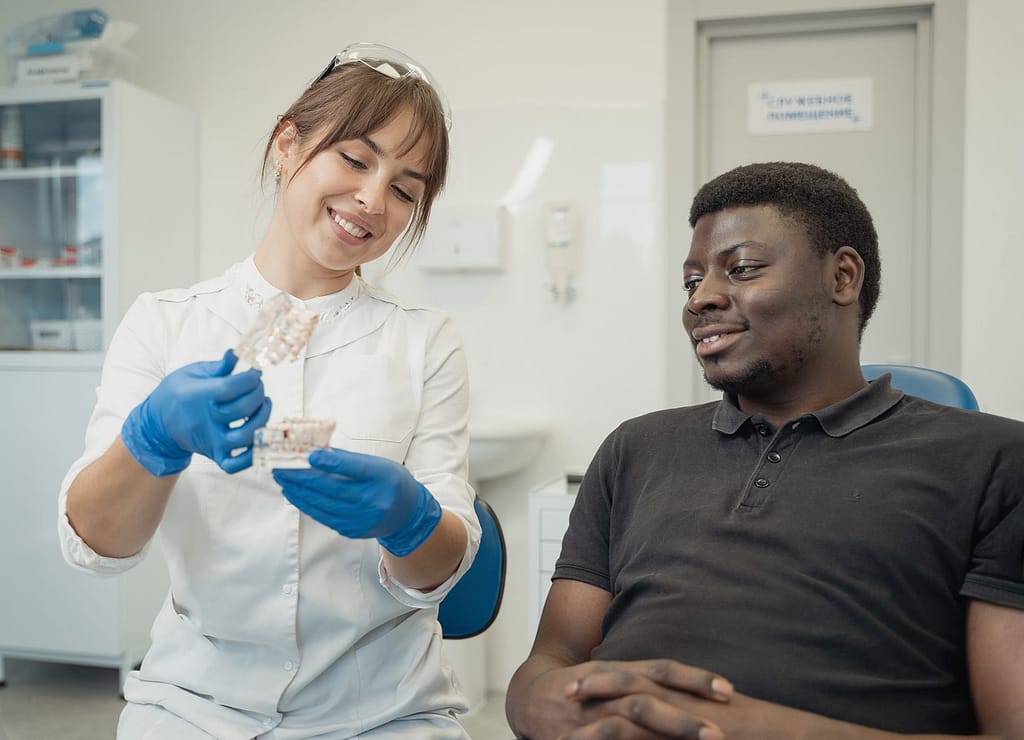Dental professional showing dental typodont to patient during visit