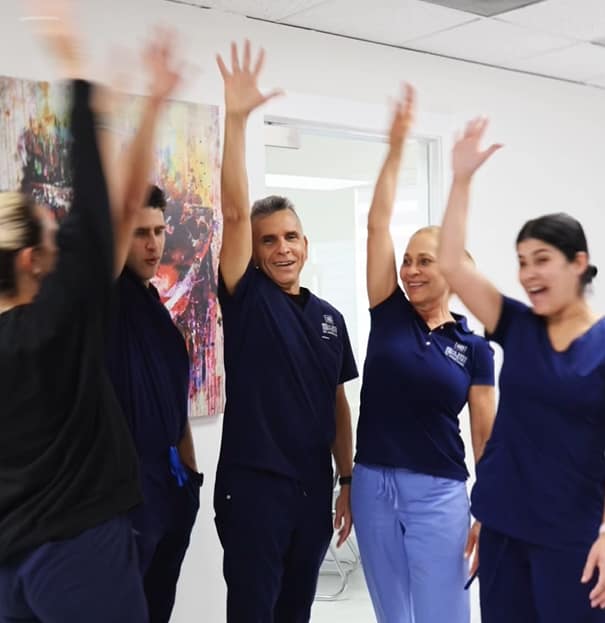 Doctor and team in the office celebrating with their hands up